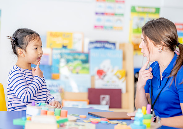 A young girl practices pronunciation with her speech therapist
