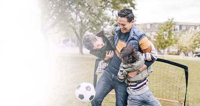 Dad and sons playing soccer